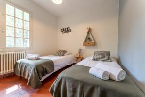 une chambre avec deux lits et une fenêtre dans l'établissement Villa Poseidon - Au Pyla à 100m du Bassin, à La Teste-de-Buch