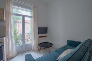 een woonkamer met een bed en een raam bij NOCNOC - Le Ceramica - Le calme en ville, T3 très fonctionnel in Montpellier