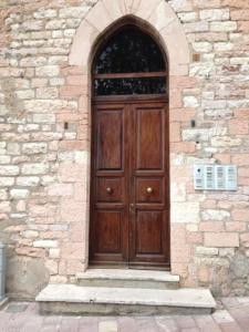uma grande porta de madeira num edifício de pedra em La belle époque di Assisi 1 em Assis