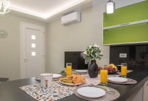 a kitchen with a table with food and orange juice at Hypatia Suites in Zakynthos Town