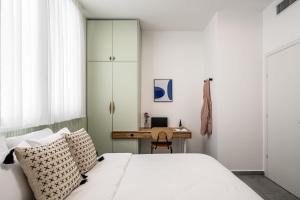 1 dormitorio con cama y escritorio en Mate ALLENBY - By HOMY, en Tel Aviv