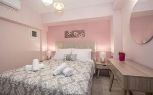 a bedroom with a large bed and a desk at Hypatia Suites in Zakynthos Town