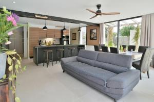 sala de estar con sofá y cocina en Maison Gwenan - Maison contemporaine pour 8 proche plage, en Saint-Cast-le-Guildo