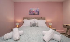 a bedroom with a large bed with white pillows at Hypatia Suites in Zakynthos Town