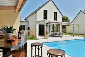a home with a swimming pool and a house at Maison Gwenan - Maison contemporaine pour 8 proche plage in Saint-Cast-le-Guildo