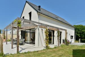 Casa blanca con una gran puerta corredera de cristal en Maison Gwenan - Maison contemporaine pour 8 proche plage, en Saint-Cast-le-Guildo