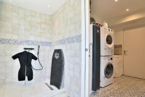 baño con lavadora y secadora en una habitación en Maison Gwenan - Maison contemporaine pour 8 proche plage, en Saint-Cast-le-Guildo