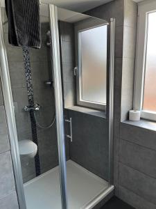um chuveiro com uma porta de vidro na casa de banho em Gasthof zur Post Hotel - Restaurant em Breckerfeld