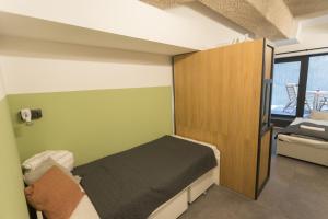 een slaapkamer met een bed en een houten kast bij Peaceful Basement Apartment with Terrace & free GYM in Boedapest