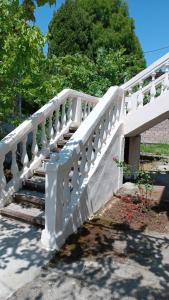 a white wooden bridge with stairs in a park at Дом под ключ у моря in Gudauta