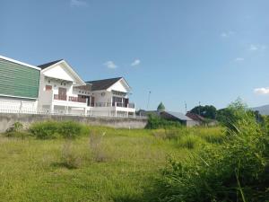 uma casa com um telhado verde e um campo de relva em sama sama villa em Midang