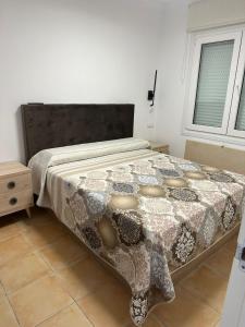 a bedroom with a bed with a comforter on it at OLIVA NOVA GOLF BEACH & RESORT club sevilla IV 2A in Oliva