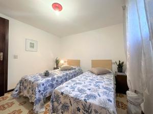 a bedroom with two beds with blue and white sheets at Villa Luisa in Lignano Sabbiadoro