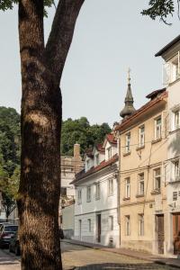 un árbol frente a un edificio al lado de una calle en April1550 Boutique Hotel en Liubliana