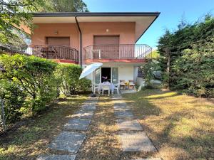 a house with a balcony and a table in the yard at Villa Luisa in Lignano Sabbiadoro