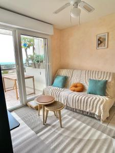 een woonkamer met een bank en een tafel bij Appartement vue exceptionnelle in Saint-Raphaël