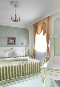 een slaapkamer met een groot bed en een raam bij Queen's Astoria Design Hotel in Belgrado