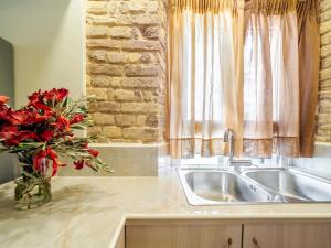 a kitchen with a sink and a vase with red flowers at Nymfes Corfu Apartments in Corfu Town +41 photos