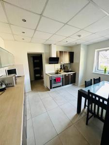 a large kitchen with a table and a counter top at Svetes house - Garden & BBQ & Parking in Liepāja