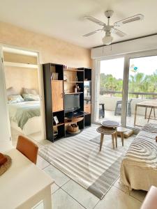 a bedroom with a bed and a living room with a tv at Appartement vue exceptionnelle in Saint-Raphaël