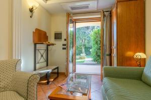 ein Wohnzimmer mit einem Sofa und einem Tisch in der Unterkunft Carpediem Roma Golf Club in Marco Simone