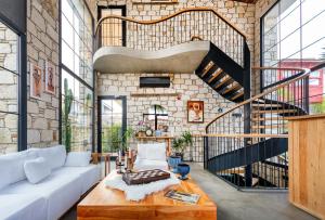 a living room with a white couch and a staircase at Dmira Alacati in Alaçatı