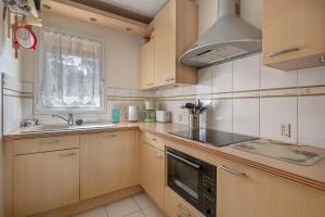 eine Küche mit Holzschränken und Spüle und einem Fenster in der Unterkunft Maison à 500m de la plage pour 4 in Saint-Brévin-lʼOcéan + 10 Fotos