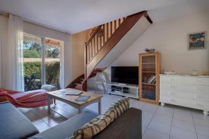 ein Wohnzimmer mit Sofa und Tisch in der Unterkunft Maison à 500m de la plage pour 4 in Saint-Brévin-lʼOcéan