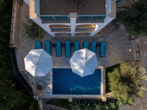 einen Blick über einen Pool mit zwei Sonnenschirmen in der Unterkunft Dolaca Villas in Sutomore