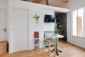 una pequeña cocina con mesa y puerta en Studio avec terrasse à 250 mètres du port en Rivedoux-Plage