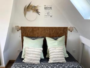a room with a bed with pillows and a mirror at La Suite Massyl - Hypercentre & Proche Plage in Dieppe