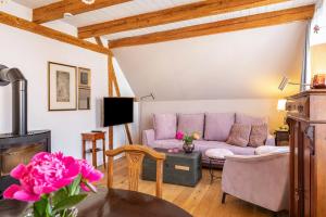 ein Wohnzimmer mit einem lila Sofa und einem Tisch in der Unterkunft Kleiner Hof Rosenrot in Königschaffhausen