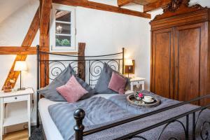 ein Schlafzimmer mit einem schwarzen Bett mit rosa und blauen Kissen in der Unterkunft Kleiner Hof Rosenrot in Königschaffhausen