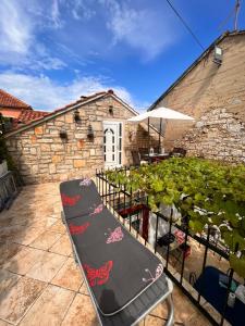 a bench sitting on a patio next to a garden at Apartment Antonia in Vrboska