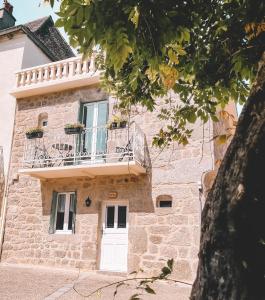 un edificio con puerta blanca y balcón en Mon Petit Coin de Paradis, en Golinhac