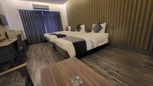 Habitación de hotel con 2 camas y mesa en Hotel Akbar International, en Rawalpindi