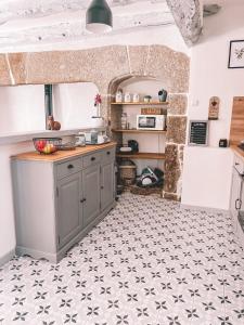 a kitchen with a counter and a tile floor at Mon Petit Coin de Paradis in Golinhac