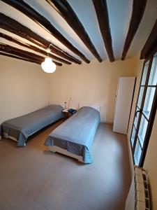 Duas camas num quarto grande com janelas em Apartamentos Rurales Mazaleón em Mazaleón