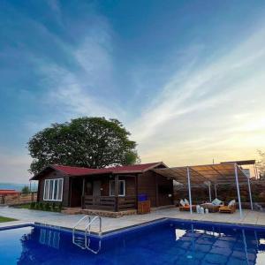 浦那Waterrock Bhor的一座小房子,前面设有一个游泳池