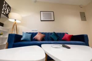 a living room with a blue couch with colorful pillows at marron studios 4 new in Cairo