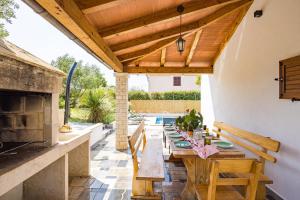 a patio with a table and a fireplace at Holiday house Mara with a private pool in Vodnjan
