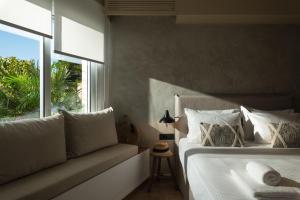 1 dormitorio con cama, ventana y sofá en Nomas lifestyle living, en La Canea