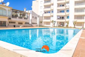 a swimming pool in front of a building at #005 Foxy B by Home Holidays in Caliços