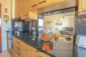een keuken met een aanrechtblad met oranje pijlen die naar een kamer wijzen bij #005 Foxy B by Home Holidays in Albufeira