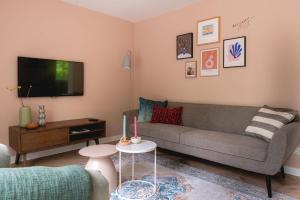 ein Wohnzimmer mit einem Sofa und einem TV in der Unterkunft Luxe Vakantiehuis Huismus Veluwe in Nunspeet