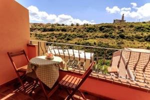una mesa y sillas en un balcón con vistas en La Colbula, en Castelsardo