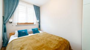 a bedroom with a large bed with blue pillows at Apartament Szept Lasu - z prywatnym parkingiem - Space Apart in Karpacz