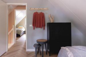 寧斯佩特的住宿－Luxe Vakantiehuis Huismus Veluwe，一间设有床铺和黑橱柜的房间和一间卧室