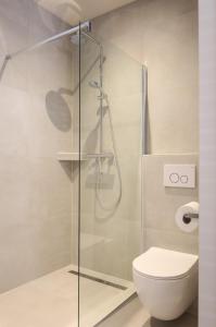 uma casa de banho com um WC e uma cabina de duche em vidro. em Zilt aan Zee em Egmond aan Zee