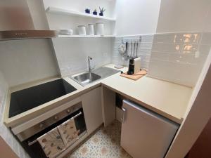 a small white kitchen with a sink and a dishwasher at La Casetta in Lerici